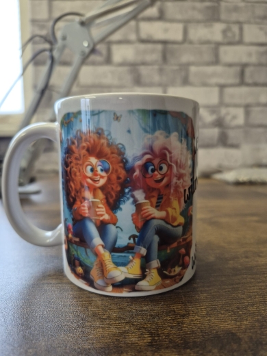 Eine weiße Keramiktasse steht auf einer Holzoberfläche vor einer Wand mit Backsteinmuster. Auf der Tasse befindet sich ein farbenfrohes Illustrationsmotiv sowie der gut lesbare Schriftzug „Ich wünschte Du wärst hier!“ in schwarzer Schrift. Rechts im Hinte