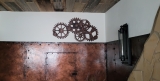Wanddekoration aus Pappelholz mit ineinandergreifenden Zahnrädern im Steampunk- und Industrial-Design an einer Wand